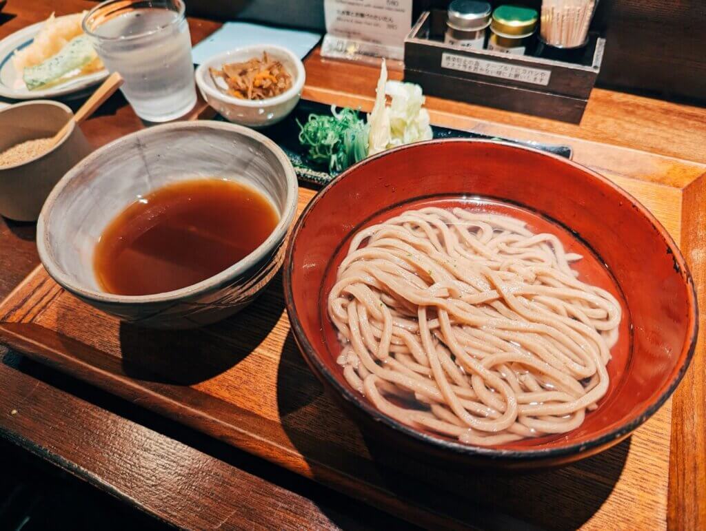 A wooden table topped with bowls of food