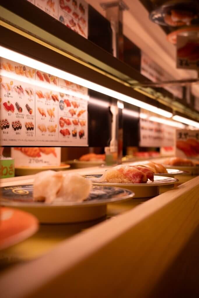 Sushi plates on a conveyor belt at a restaurant.